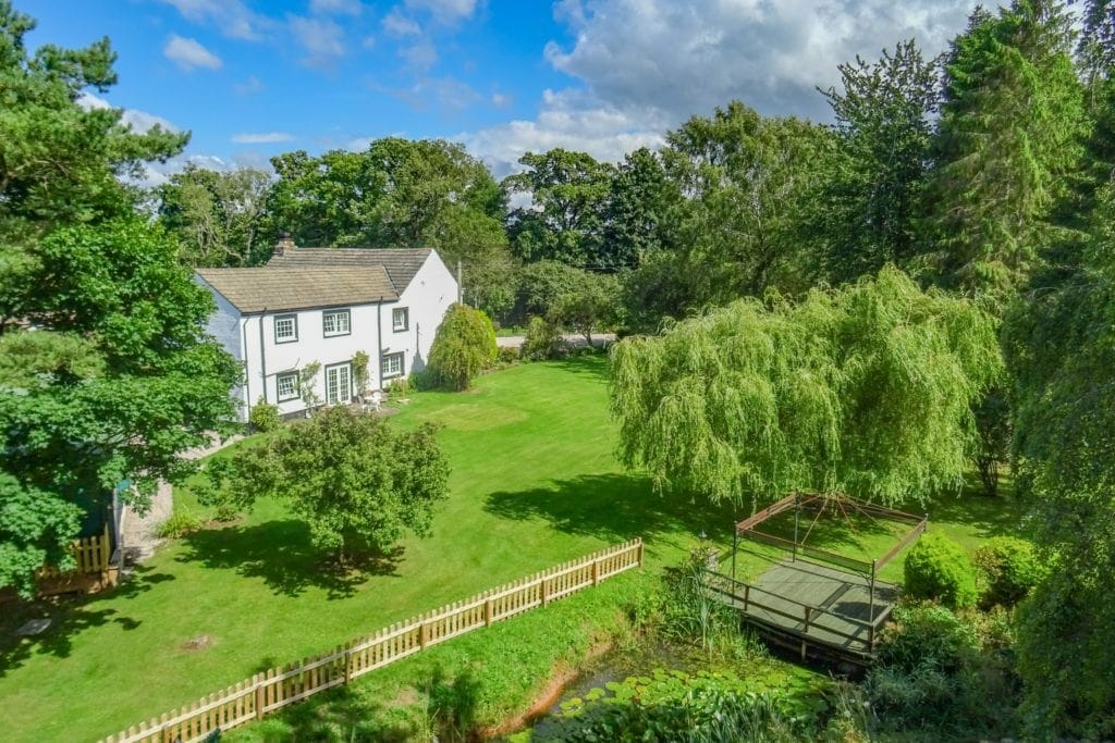 An 18th century farmhouse has been put on the market with a guide price of £1,275,000. 

Wells House, a four-bedroom farmhouse with 'high-quality' stables, a tack room, 12 acres of grazing land, a two-bedroom lodge, woodland, extensive gardens and a range of outbuildings. 

Wells House is located just minutes from Skelton, near Penrith, and is being sold through the Penrith office of H&H Land & Estates. 